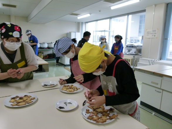 クッキーにチョコペンで模様をつけている写真